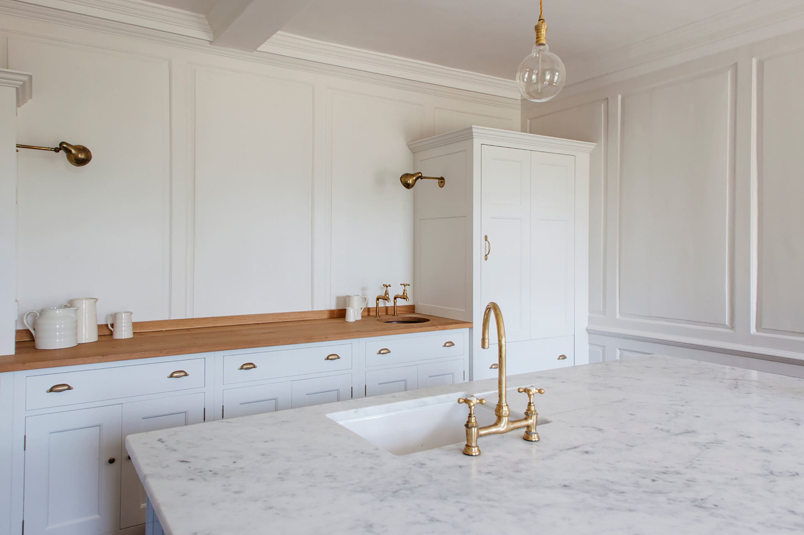  The Rectory Kitchen featuring ‘Boiled Dishcloth’ Spitalfields cabinets with honed Carrara Marble Worktops, and oiled Pippy Oak worktop and Copper sink. Ceramic Sink to Island. Bib taps. Bespoke cupboards.